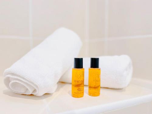 deux bouteilles d'huiles essentielles à côté d'un rouleau de papier toilette dans l'établissement Le Bel Époque - Logement Centre Cannes, à Cannes