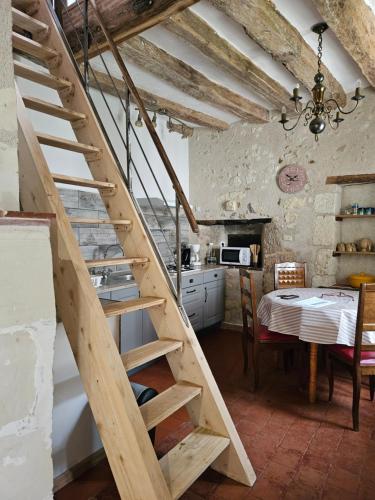 a wooden staircase in a kitchen with a table at Moulin de Galerne, Le gite du Meunier in Seigy