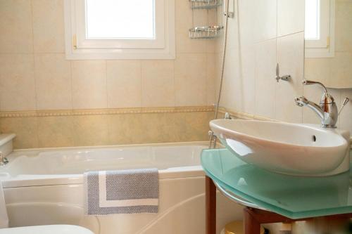 a bathroom with a sink and a bath tub at Prince Apartments in Volissos