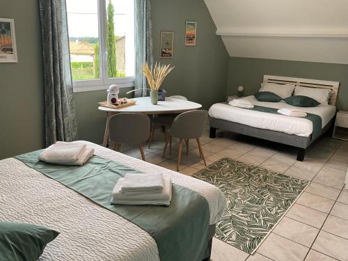 um quarto com duas camas e uma mesa em Casa Di fiore em Maubourguet
