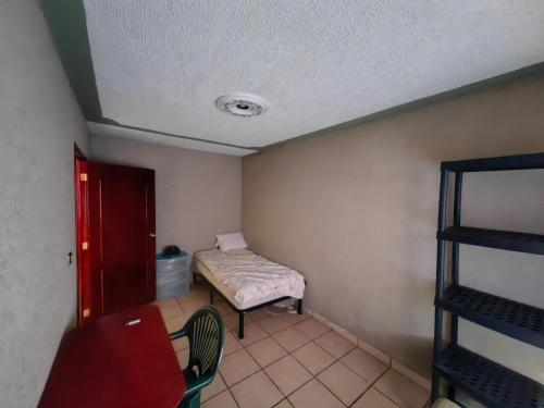 a small room with a bed and a table and chair at Casa Doña Ade in Xalapa