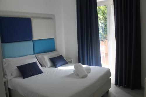 a bedroom with a bed with a blue headboard and a window at Eden Bleu in Vico Equense