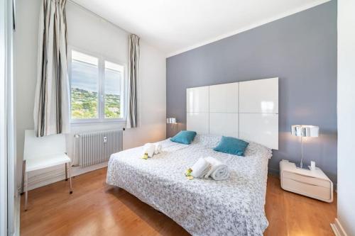 une chambre avec un grand lit avec des oreillers bleus dans l'établissement Superbe appartement vue mer Gallia, à Cannes