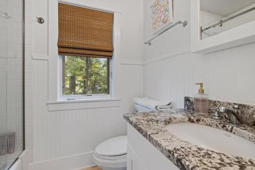 a white bathroom with a sink and a toilet at Bella and Dulce's Lakehouse in Union Pier