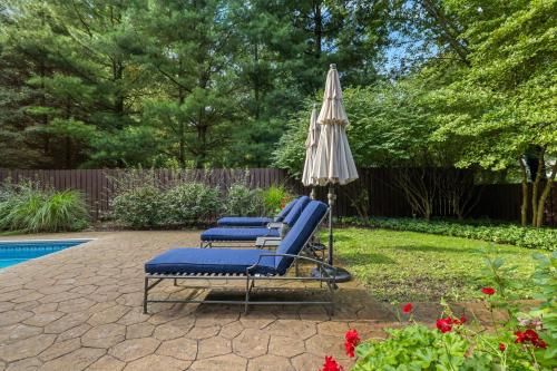 two lounge chairs and an umbrella next to a pool at Bella and Dulce's Lakehouse in Union Pier