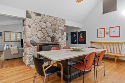 a dining room with a stone wall and a table and chairs at Casa Azur in Union Pier