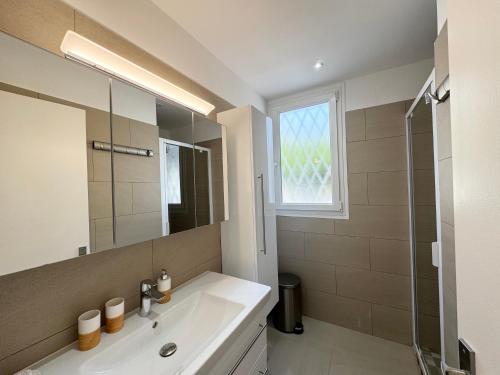 a bathroom with a sink and a mirror and a shower at Appartement 3ch avec terrasse et jardin à 400m de la plage in Cavalaire-sur-Mer