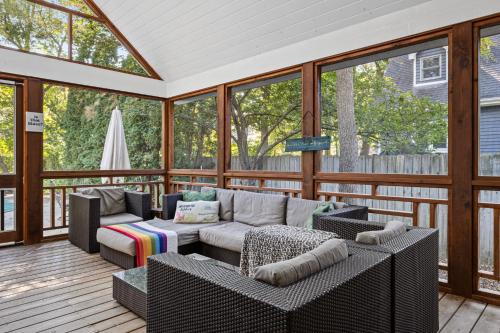 a screened in porch with a couch and chairs at Casa Azur in Union Pier