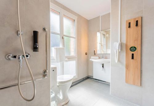 ein Bad mit einer Dusche, einem WC und einem Waschbecken in der Unterkunft B&B HOTEL Arras Centre Les Places in Arras