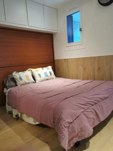 - une chambre avec un lit doté de draps violets et une fenêtre dans l'établissement Le Hameau, à Allos