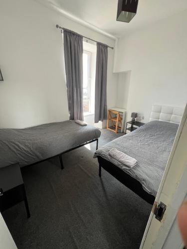 a bedroom with two beds and a window at Easy sleep in Dundee