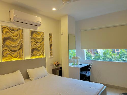 a bedroom with a bed and a desk and a window at Calm and Cozy- Tffstays in Lucknow