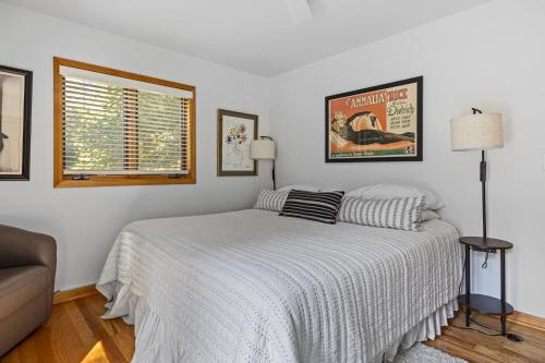 a white bedroom with a bed and a window at Casa Azur in Union Pier