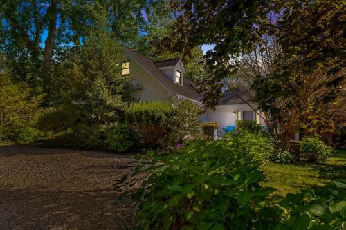 a white house with trees and plants in the yard at Casa Azur in Union Pier
