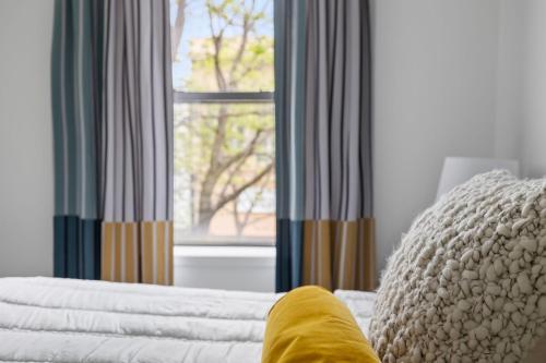 a bed with a pillow and a window with curtains at City View Loft in Saint Joseph