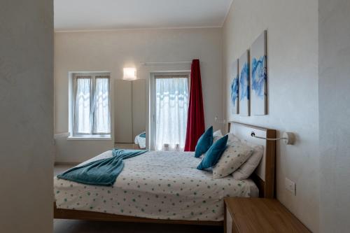 a bedroom with a bed with blue pillows at Villa Vitali - Bellagio in Bellagio