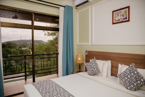 a bedroom with a bed and a large window at Greenside Hotel in Arusha