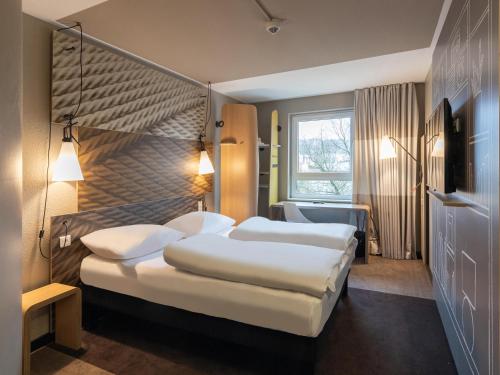 ヴッパータールにあるB&B HOTEL Wuppertal-Cityのベッド2台とテレビが備わるホテルルームです。