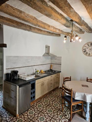 une cuisine avec un évier et une cuisinière four supérieur dans l'établissement Moulin de Galerne, Le gite du Boulanger, à Seigy