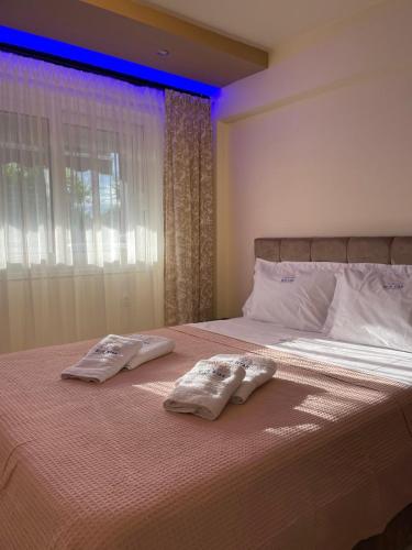 a bedroom with two towels on a bed with a window at BLUE STAR Apartments #8 in Paralia Katerinis