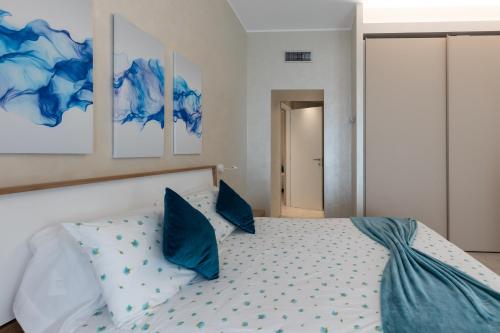 a bedroom with a bed with blue pillows at Villa Vitali - Bellagio in Bellagio