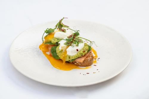 a white plate with a dish on a white table at Woodlands Park Hotel in Cobham