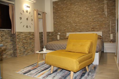 una camera con una sedia gialla e un letto di Guesthouse Taranto Centro a Taranto