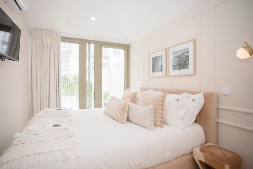 - une chambre blanche avec un grand lit blanc et des oreillers dans l'établissement Liiiving in Porto - Soho Urban Retreat, à Porto