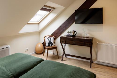 a bedroom with a bed and a desk with a television at Schloss Hertefeld & Hertefeldhof in Weeze