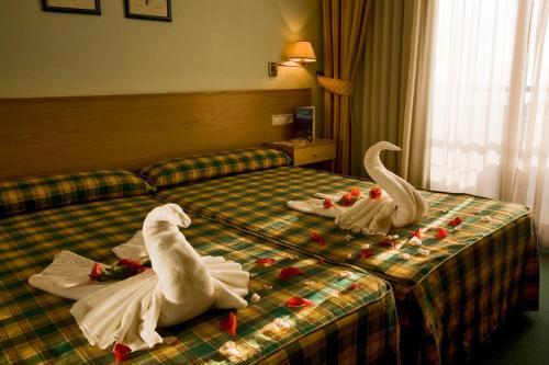 two swans made out of towels on a bed at Hotel Oca Vermar in Aios