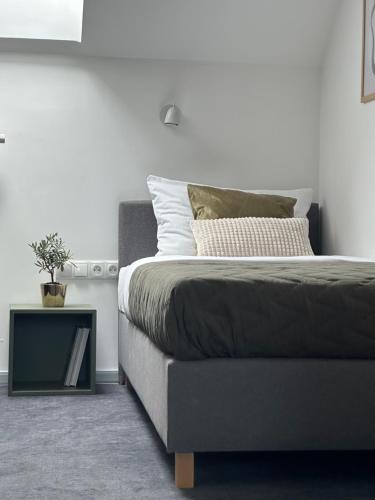 a bedroom with a bed and a table with a plant on it at Moment in Strzelce Opolskie