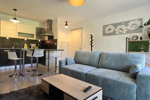 un salon avec un canapé bleu et une cuisine dans l'établissement Le Tranquille, à Thonon-les-Bains