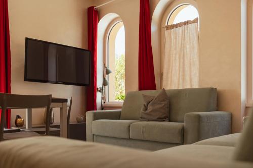 a living room with a couch and a flat screen tv at Villa Vitali - Bellagio in Bellagio
