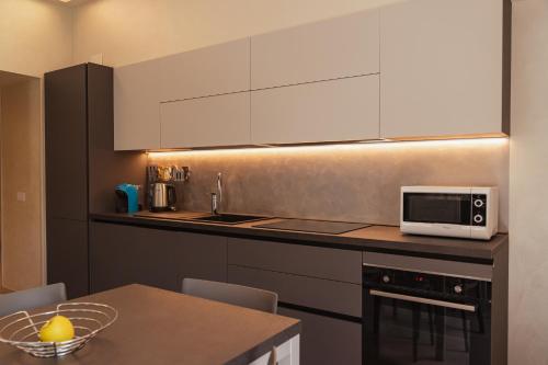 a kitchen with a table and a microwave on a counter at Villa Vitali - Bellagio in Bellagio