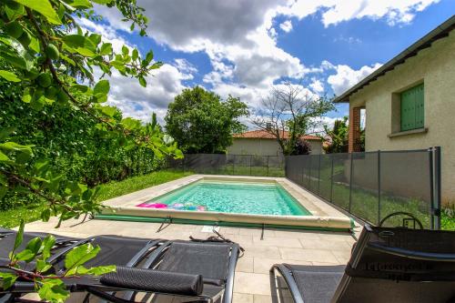 - une piscine avec des chaises dans l'arrière-cour dans l'établissement Les 3 Pitchounes, à Albi
