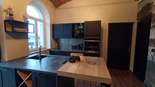 a kitchen with blue cabinets and a wooden counter top at Écuries Val de Mai 35 pers 5 Gîtes 15 min Amiens in Talmas
