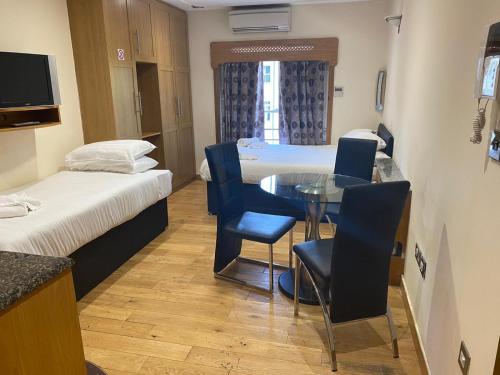 a room with two beds and a table and chairs at MSK Superior in London