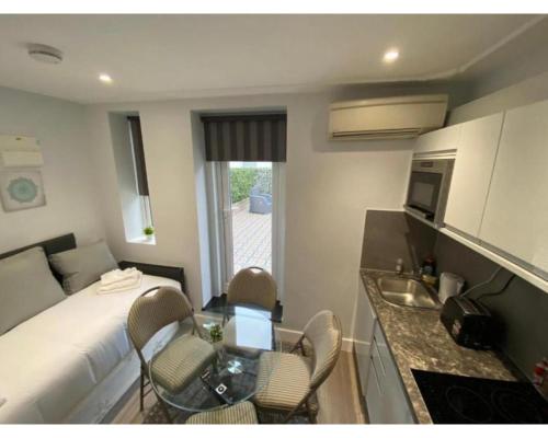 a small room with a bed and a table and chairs at MSK Superior in London