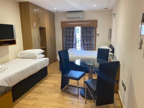 a room with two beds and a table and chairs at MSK Superior in London