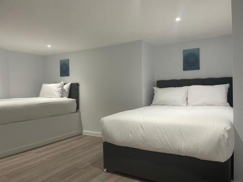 a bedroom with two beds with white pillows at MSK Superior in London