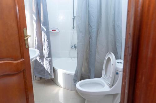 a bathroom with a toilet and a shower and a sink at Kigali Green View Apartments in Kigali
