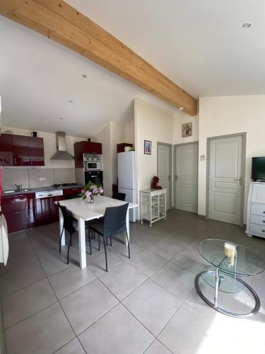 une cuisine et une salle à manger avec une table et des chaises dans l'établissement maison de lachanau, à Hourtin