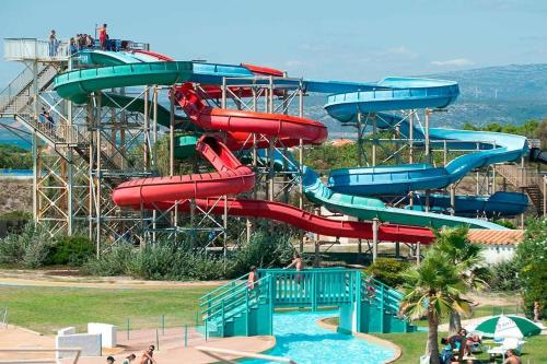 un toboggan aquatique dans un parc aquatique avec des gens dessus dans l'établissement 2min à pied de la plage Grande terrasse, au Barcarès