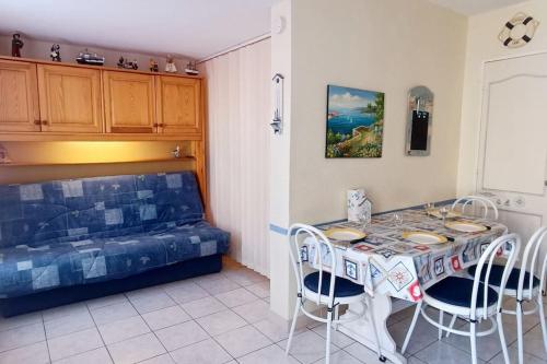 - une salle à manger avec une table, des chaises et un lit dans l'établissement 2min à pied de la plage Grande terrasse, au Barcarès