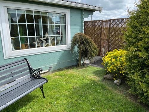 a bench in front of a house with a window at Adorable Cabin in the Countryside in Portlaoise