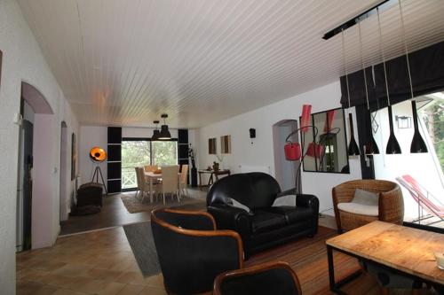 un salon avec une chaise en cuir noir et une table dans l'établissement Annonce professionnelle. Jolie maison de vacances 4 chambres avec jardin à proximité de la mer., à Hardelot-Plage