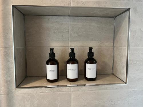three bottles of wine sitting on a shelf at Adorable Cabin in the Countryside in Portlaoise