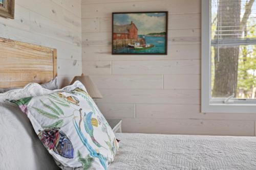 a bed with a pillow and a picture on the wall at Gasthaus Fox in Bridgman