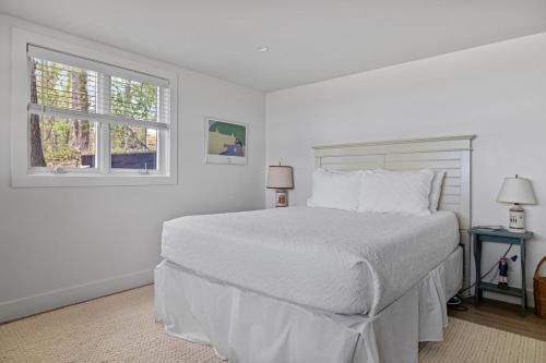 a white bedroom with a bed and a window at Gasthaus Fox in Bridgman