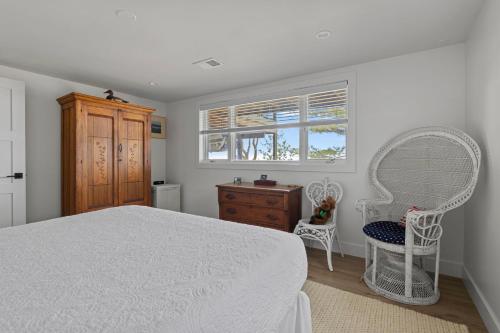 a bedroom with a bed and two chairs and a window at Gasthaus Fox in Bridgman